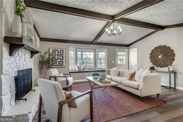 living room with lofted ceiling with beams, a textured ceiling, hardwood / wood-style floors, and a fireplace