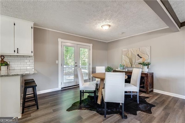 dining room with ornamental molding, french doors, a textured ceiling, and dark hardwood / wood-style floors