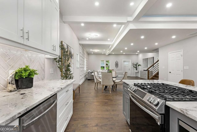 kitchen with stainless steel appliances, white cabinetry, tasteful backsplash, light stone countertops, and dark hardwood / wood-style flooring