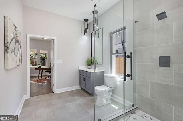 bathroom with tiled shower, vanity, and toilet