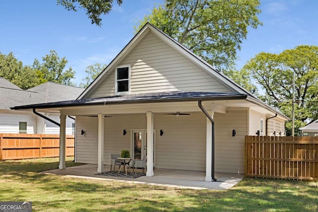 back of property with a lawn and a patio area