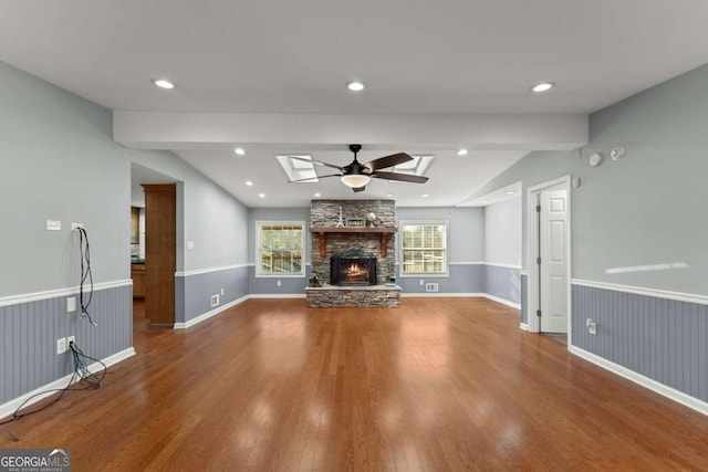 unfurnished living room featuring a fireplace, ceiling fan, vaulted ceiling, and hardwood / wood-style flooring