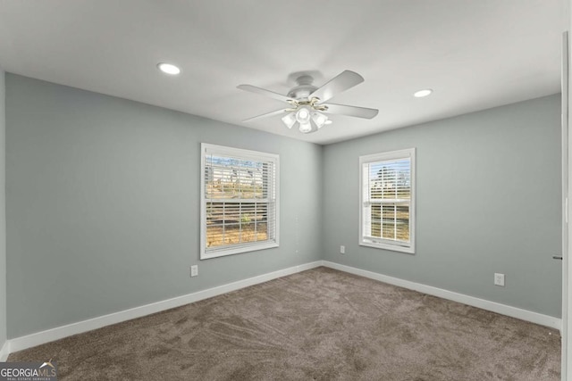 carpeted empty room with ceiling fan and a healthy amount of sunlight