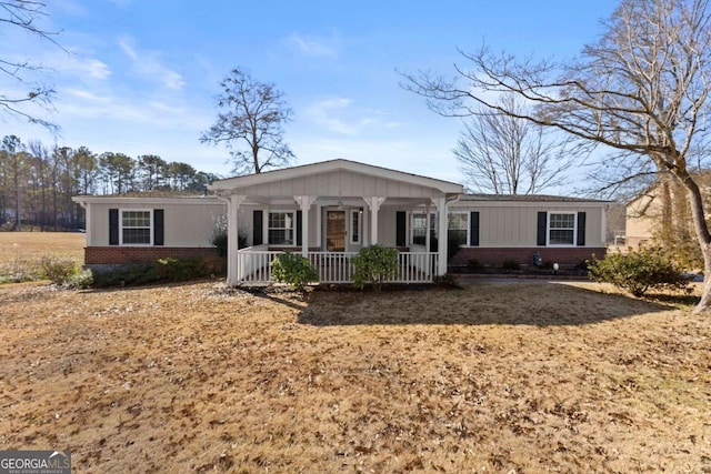 ranch-style house with covered porch and a front lawn