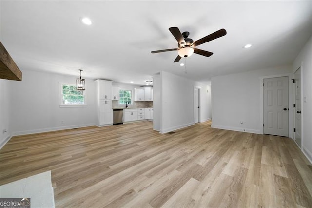 unfurnished living room featuring ceiling fan and light wood-type flooring