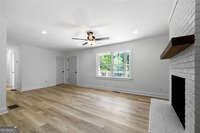 unfurnished living room featuring ceiling fan, light wood-type flooring, and a fireplace