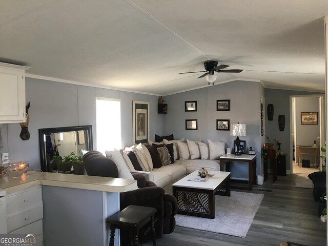 living room featuring vaulted ceiling, ceiling fan, dark hardwood / wood-style flooring, and ornamental molding