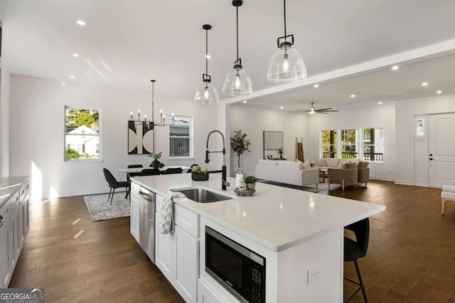 kitchen featuring sink, white cabinetry, a kitchen island with sink, and appliances with stainless steel finishes