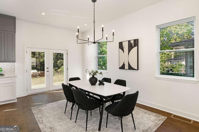 dining space featuring a notable chandelier, dark wood-type flooring, and french doors