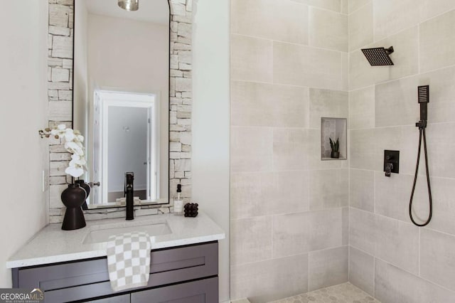 bathroom with vanity and tiled shower