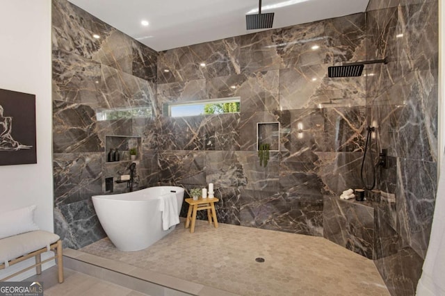 bathroom featuring shower with separate bathtub and tile walls