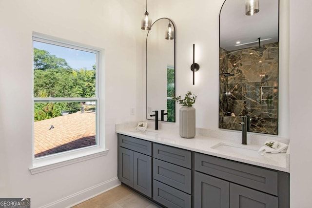 bathroom featuring a healthy amount of sunlight, tiled shower, and vanity