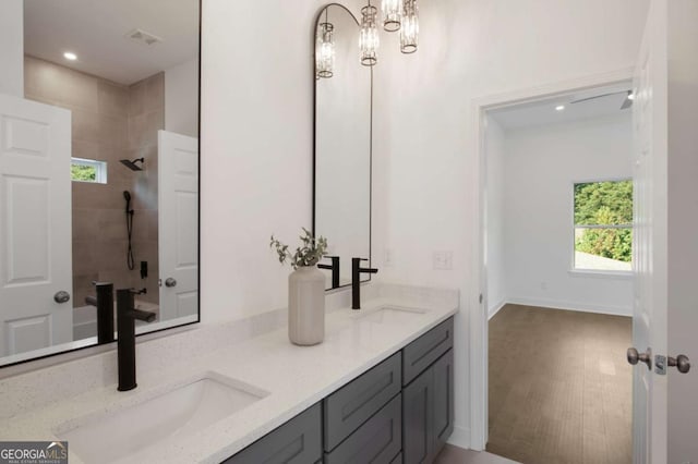 bathroom featuring a tile shower, wood-type flooring, and vanity