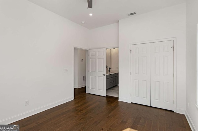 unfurnished bedroom with ceiling fan, a closet, and dark hardwood / wood-style flooring