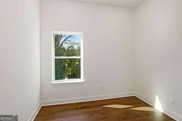 empty room with a healthy amount of sunlight and dark wood-type flooring