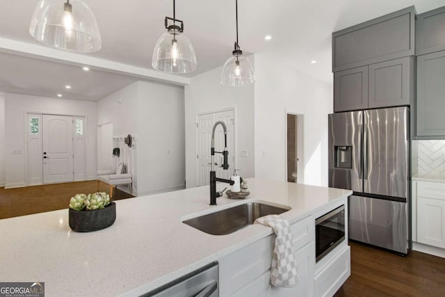 kitchen featuring stainless steel appliances, light stone countertops, pendant lighting, and gray cabinets