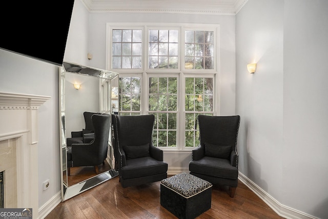 sitting room with a high end fireplace, crown molding, and dark hardwood / wood-style floors