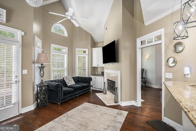 living room featuring crown molding, ceiling fan, high vaulted ceiling, dark hardwood / wood-style floors, and a fireplace