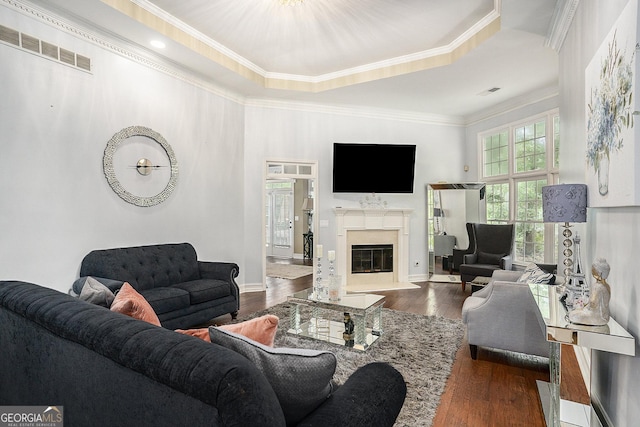 living room featuring ornamental molding, a tray ceiling, and dark hardwood / wood-style floors