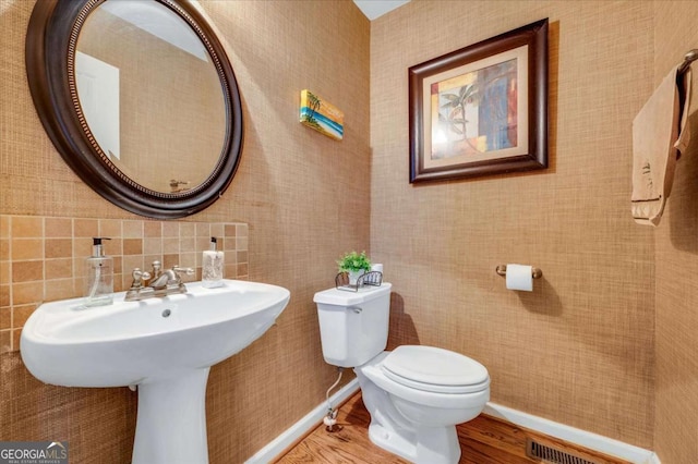 bathroom featuring sink, toilet, and wood-type flooring