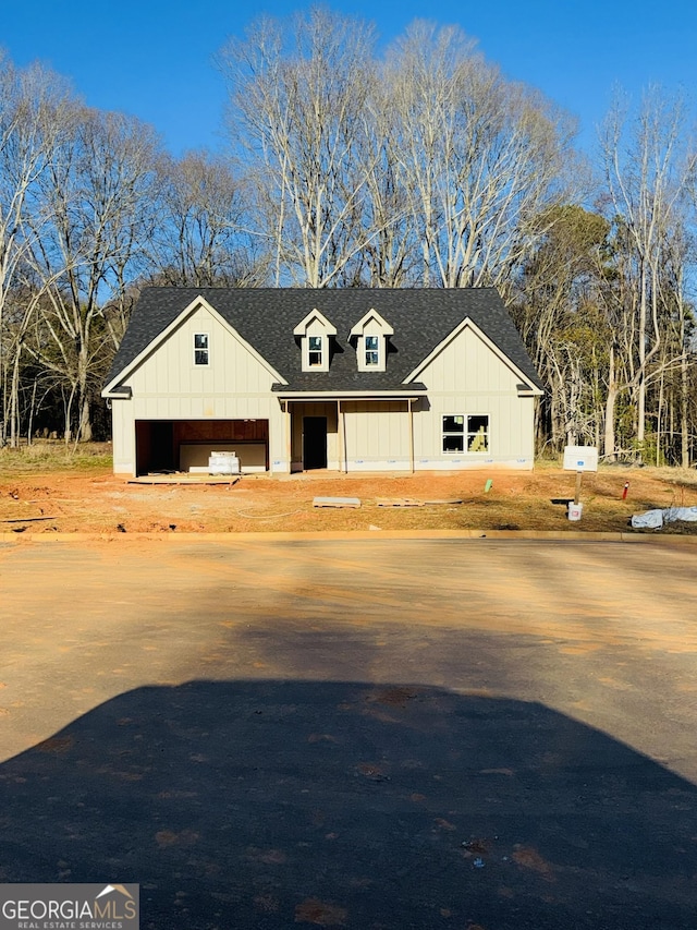 modern inspired farmhouse featuring roof with shingles