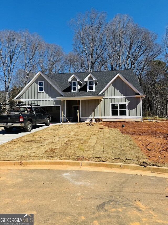 modern farmhouse with a shingled roof and board and batten siding