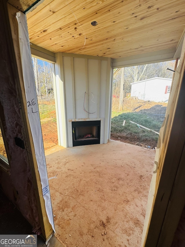 doorway to outside with carpet floors, wood ceiling, and a fireplace