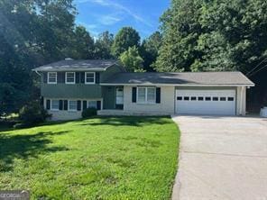 split level home with a garage, a front yard, and concrete driveway