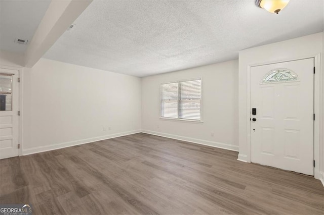 entryway featuring a textured ceiling and dark hardwood / wood-style flooring