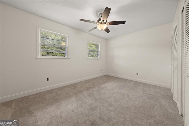 unfurnished bedroom with ceiling fan, a closet, and light colored carpet