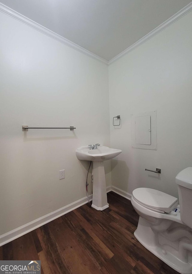 bathroom featuring toilet, ornamental molding, hardwood / wood-style flooring, and sink