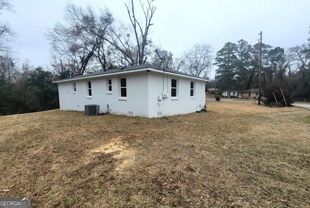 view of property exterior with a lawn and central air condition unit