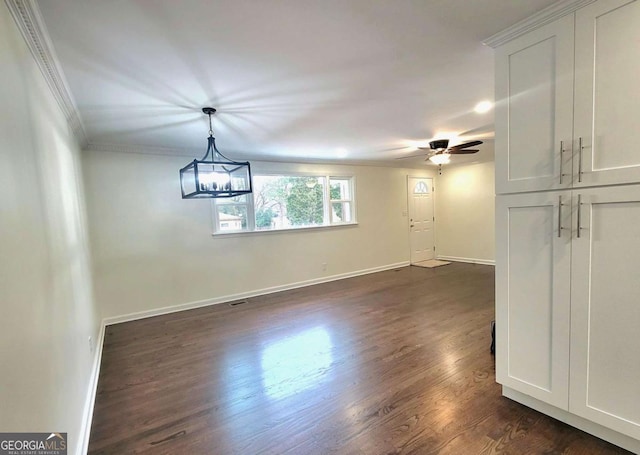 interior space with ceiling fan, dark hardwood / wood-style floors, and ornamental molding