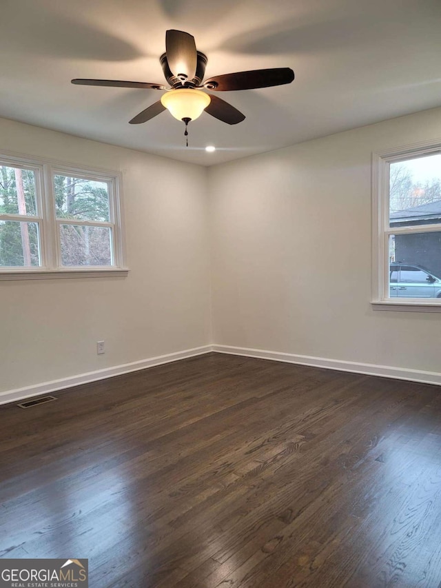 spare room with dark wood-type flooring and ceiling fan