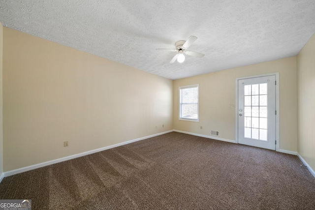 carpeted spare room with a textured ceiling and ceiling fan