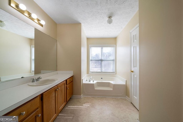 bathroom with a textured ceiling, tile patterned floors, vanity, and a bathing tub