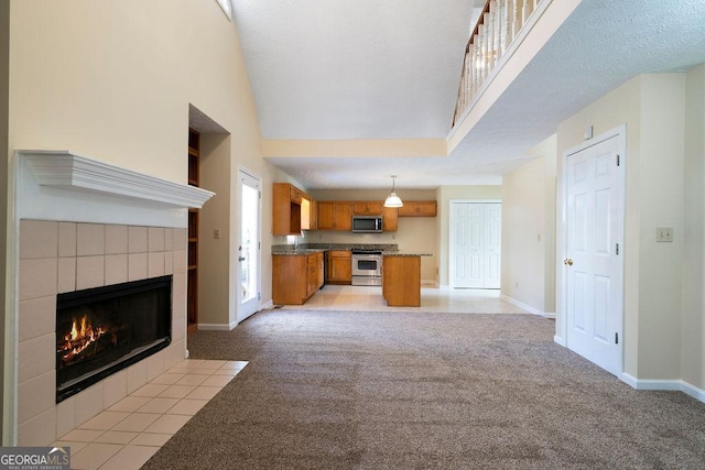 unfurnished living room featuring light colored carpet, high vaulted ceiling, and a fireplace