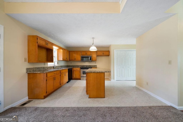 kitchen with appliances with stainless steel finishes, light colored carpet, pendant lighting, a kitchen island, and sink