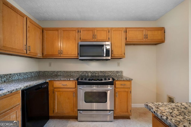 kitchen with stone counters, a textured ceiling, appliances with stainless steel finishes, and light tile patterned flooring