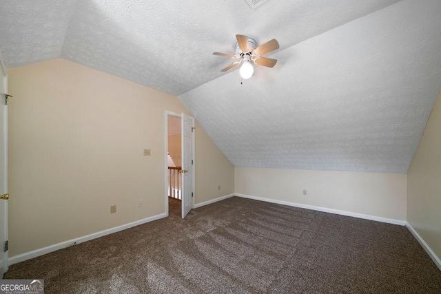 bonus room with vaulted ceiling, a textured ceiling, ceiling fan, and dark carpet