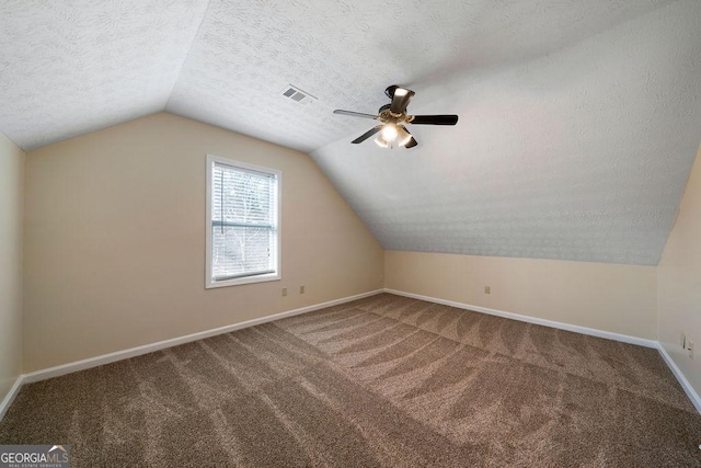 bonus room featuring a textured ceiling, ceiling fan, vaulted ceiling, and carpet floors