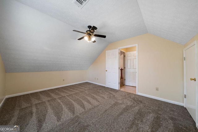 additional living space with ceiling fan, a textured ceiling, light carpet, and vaulted ceiling