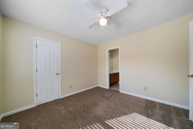 unfurnished bedroom with ensuite bathroom, a textured ceiling, carpet floors, and ceiling fan