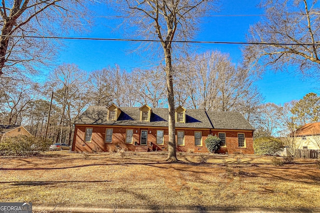 cape cod home with a front lawn