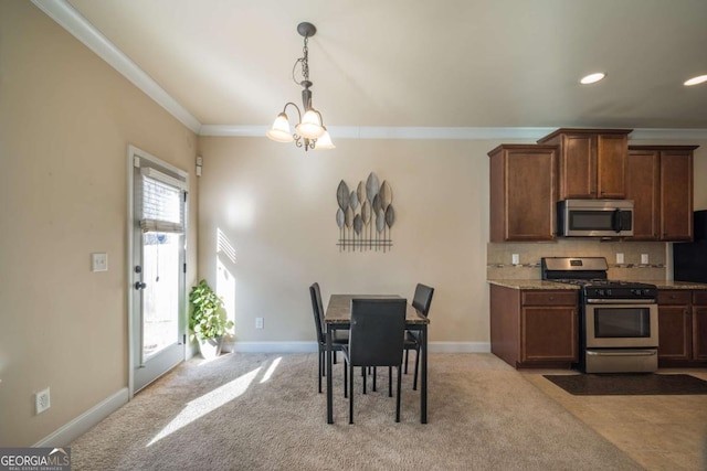 kitchen featuring light colored carpet, plenty of natural light, stainless steel appliances, and a notable chandelier