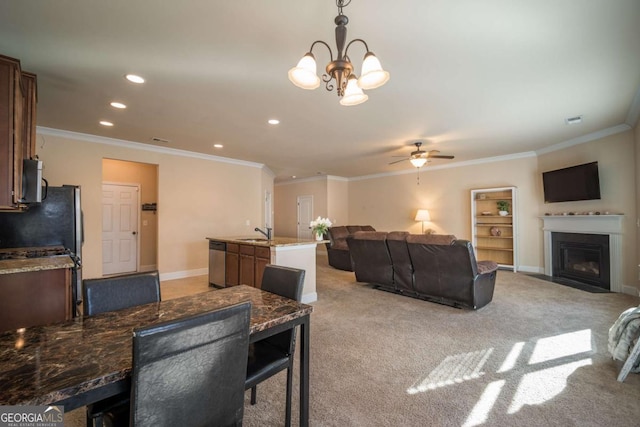 carpeted living room with ceiling fan with notable chandelier, sink, and ornamental molding