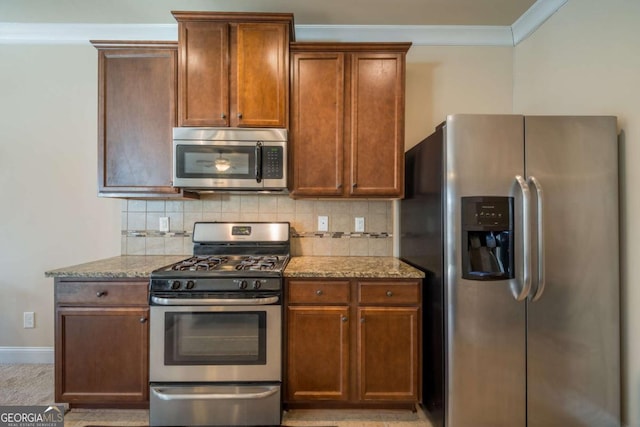 kitchen with light stone counters, ornamental molding, stainless steel appliances, and tasteful backsplash