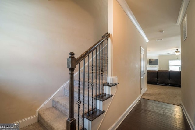 staircase with ceiling fan, ornamental molding, and hardwood / wood-style floors