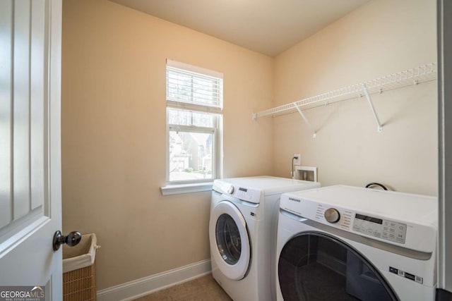 washroom with tile patterned flooring, plenty of natural light, and washing machine and clothes dryer