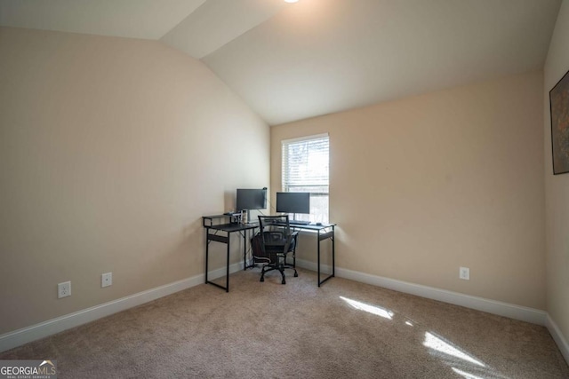 carpeted home office featuring vaulted ceiling